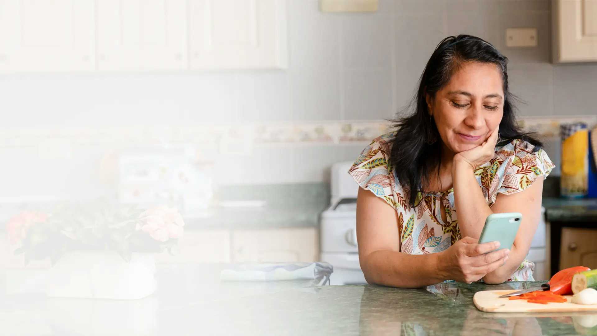 Imagen de una mujer utilizando Ualá desde su celular para cobrar su asignación.